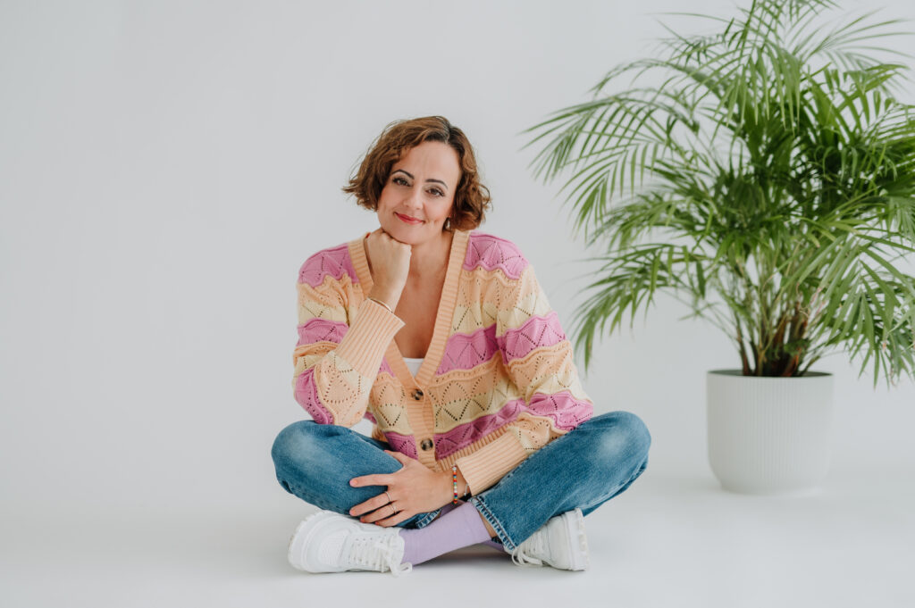 Coach Susan Zotz vor heller Wand in Strickoberteil